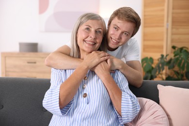 Photo of Happy son hugging his mother at home