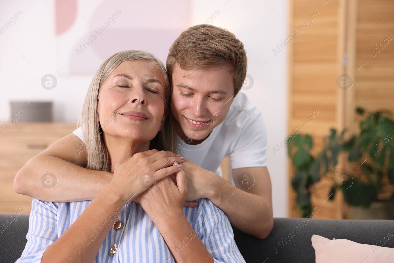 Photo of Happy son hugging his mother at home
