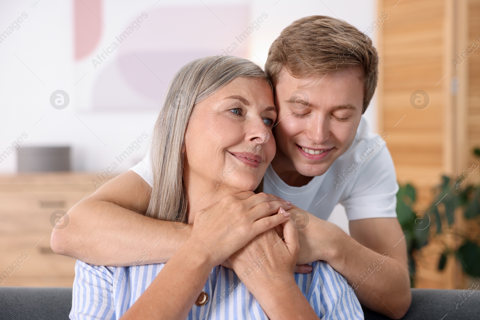 Happy son hugging his mother at home Photo of Happy son hugging his mother at home