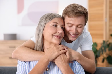 Photo of Happy son hugging his mother at home