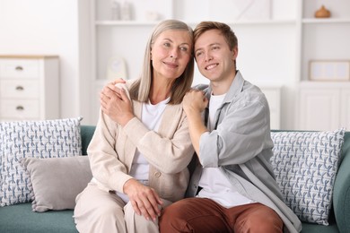 Photo of Happy son and his mother on sofa at home