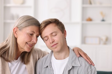 Photo of Happy mother and her son at home. Space for text