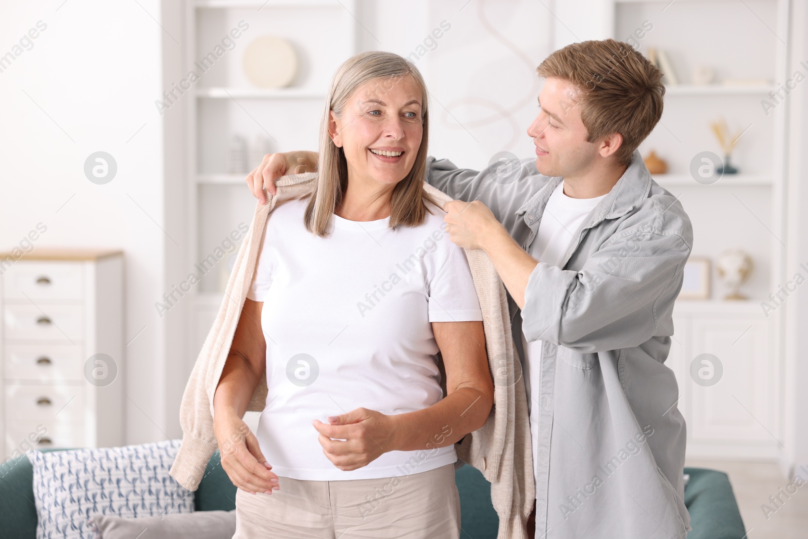 Photo of Son taking care of his happy mother at home. Family bonding