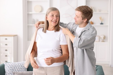 Photo of Son taking care of his happy mother at home. Family bonding