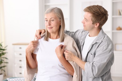 Photo of Son taking care of his mother at home. Family bonding