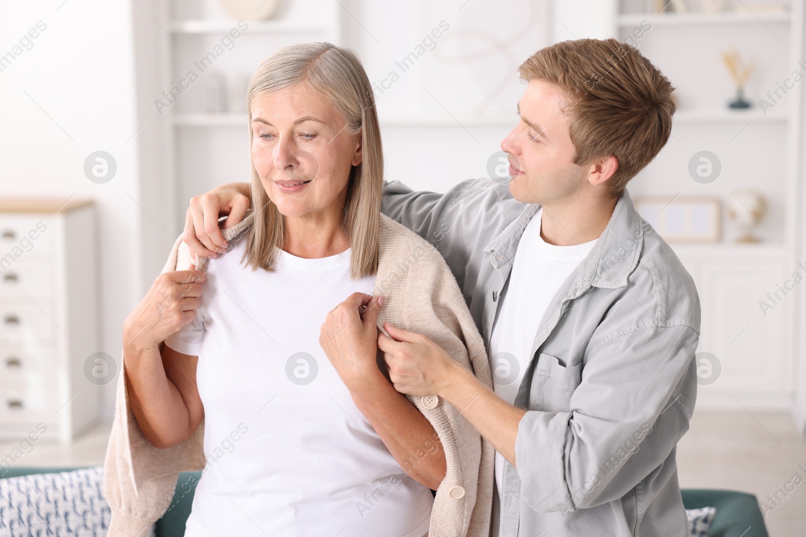 Photo of Son taking care of his mother at home. Family bonding