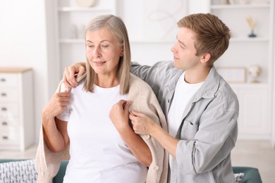 Photo of Son taking care of his mother at home. Family bonding