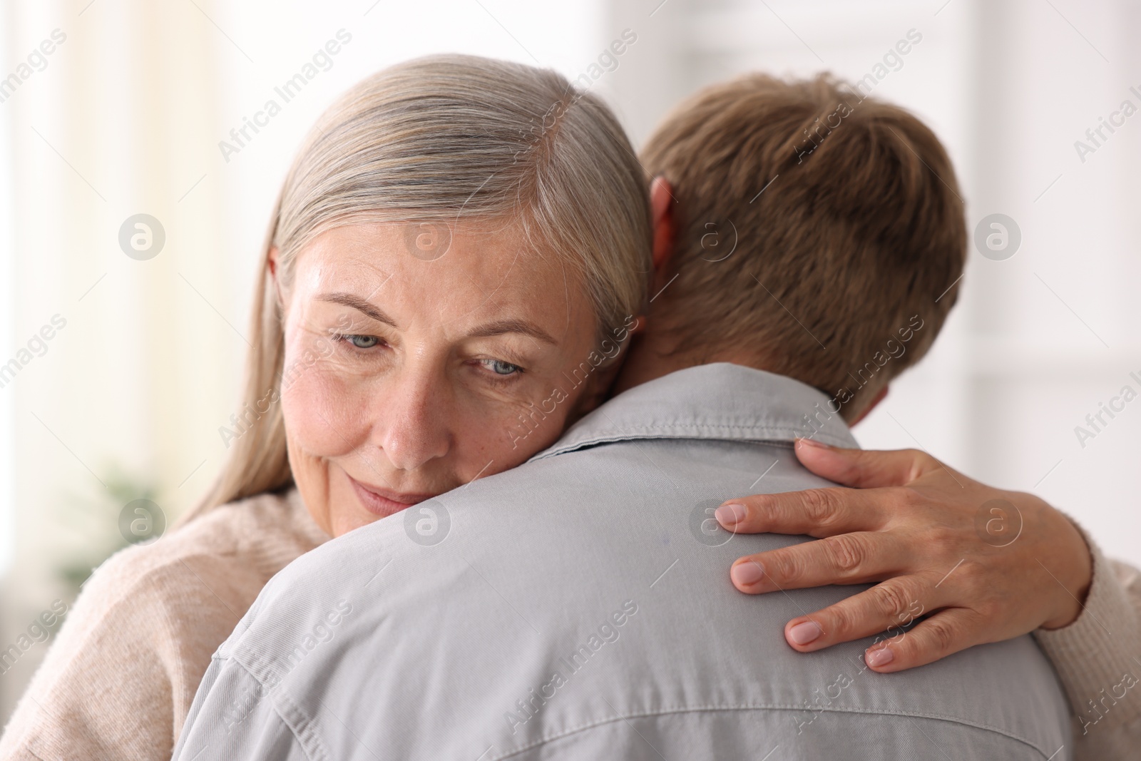 Photo of Mother hugging her son at home. Family bonding