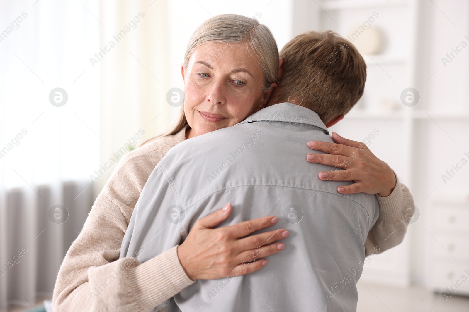 Photo of Mother hugging her son at home. Family bonding