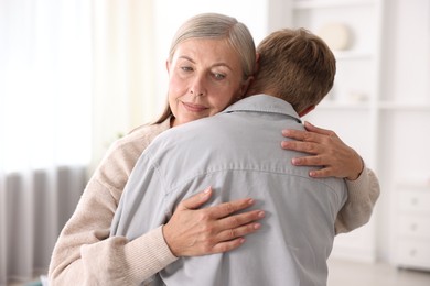 Photo of Mother hugging her son at home. Family bonding
