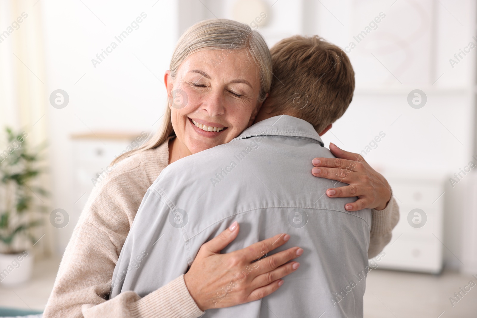 Photo of Happy mother hugging her son at home