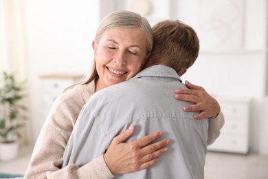 Photo of Happy mother hugging her son at home
