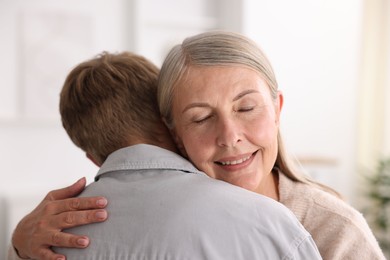 Photo of Happy mother hugging her son at home