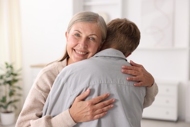 Photo of Happy mother hugging her son at home