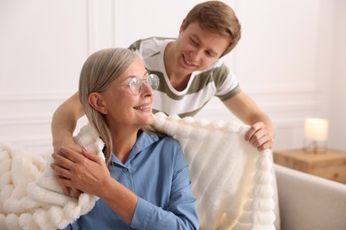 Photo of Smiling son taking care of his mother at home. Family bonding