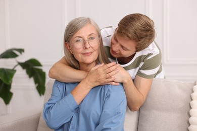 Photo of Son hugging his mother at home. Family bonding