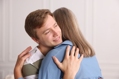 Photo of Smiling son hugging his mother at home
