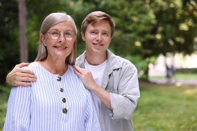 Photo of Family portrait of happy mother and her son outdoors. Space for text
