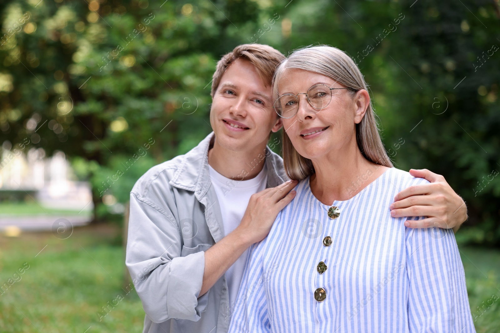 Photo of Family portrait of happy mother and her son outdoors. Space for text