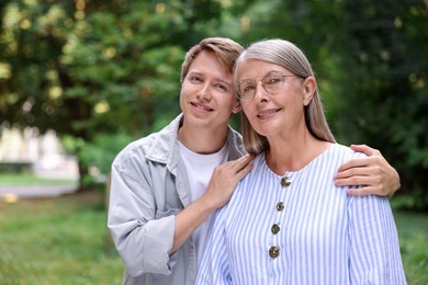 Photo of Family portrait of happy mother and her son outdoors. Space for text