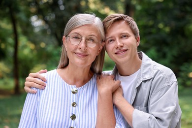 Photo of Family portrait of mother and her son outdoors