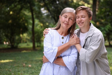 Photo of Mother and her happy son outdoors, space for text. Family bonding