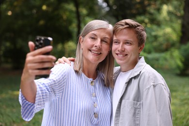 Photo of Smiling mother and her son taking selfie outdoors