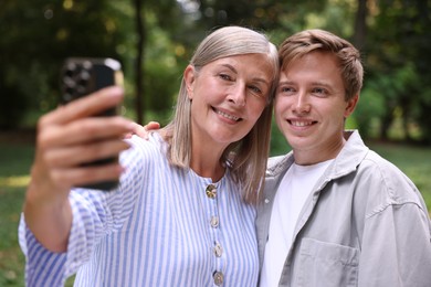 Photo of Smiling mother and her son taking selfie outdoors