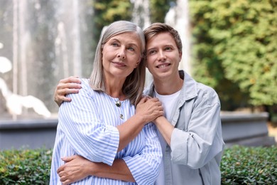 Photo of Mother and her son in front of fountain outdoors. Family bonding