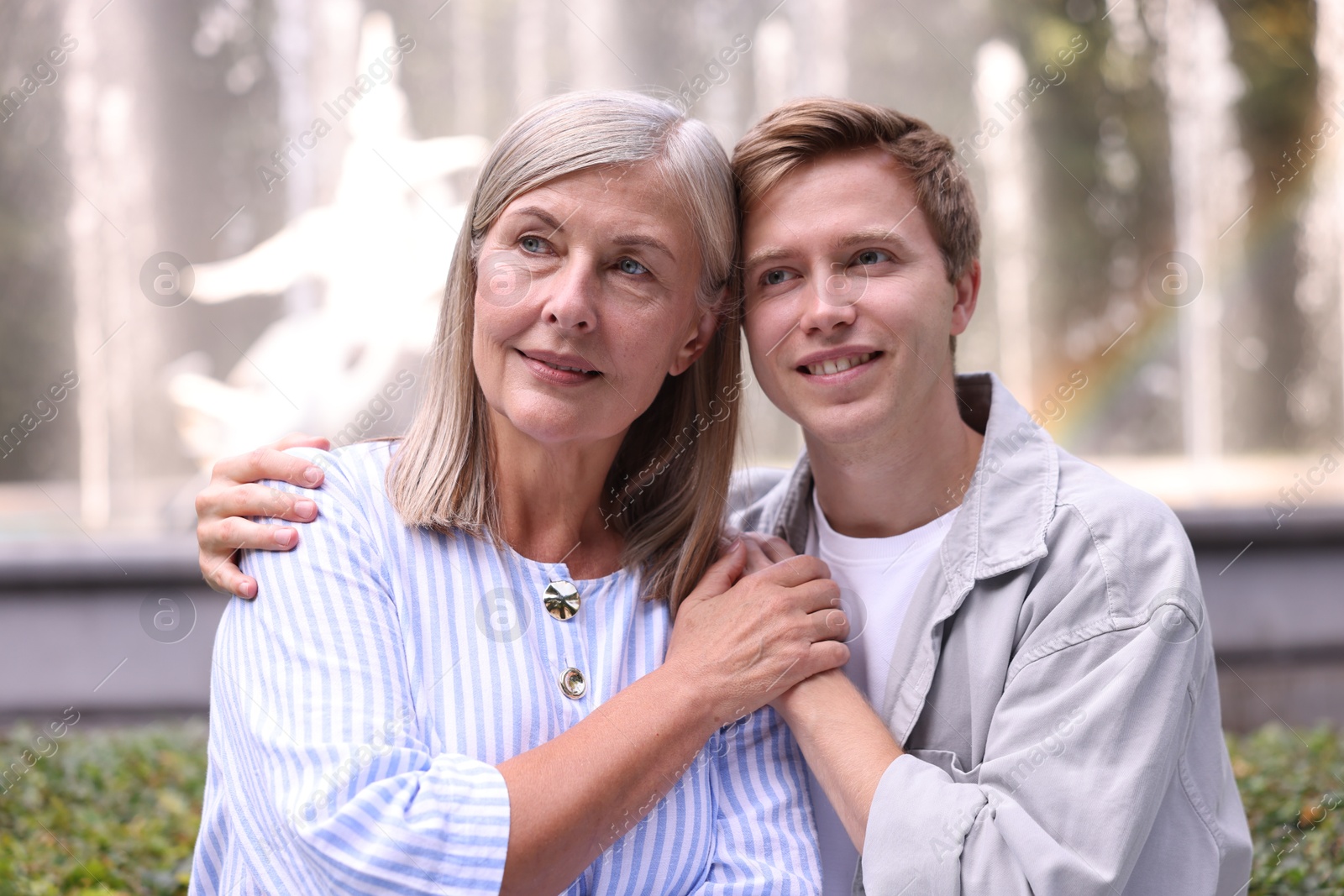 Photo of Mother and her son in front of fountain outdoors. Family bonding