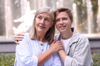 Photo of Mother and her son in front of fountain outdoors. Family bonding