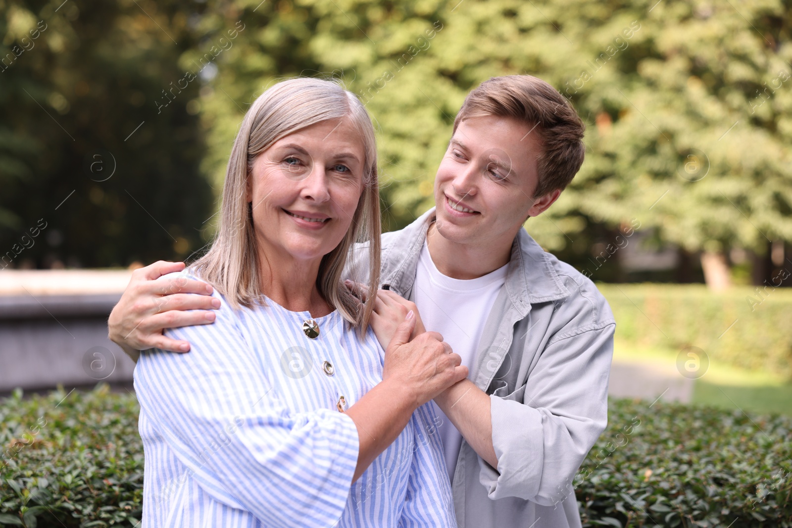 Photo of Family portrait of smiling mother and her son outdoors