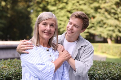 Photo of Family portrait of smiling mother and her son outdoors