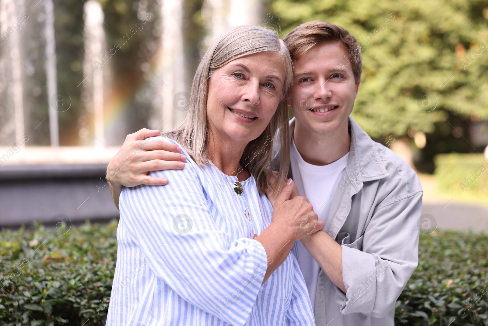 Photo of Family portrait of smiling mother and her son outdoors