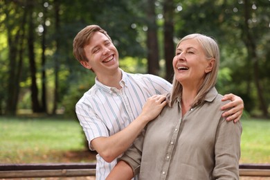 Photo of Mother and her son laughing in park. Family bonding