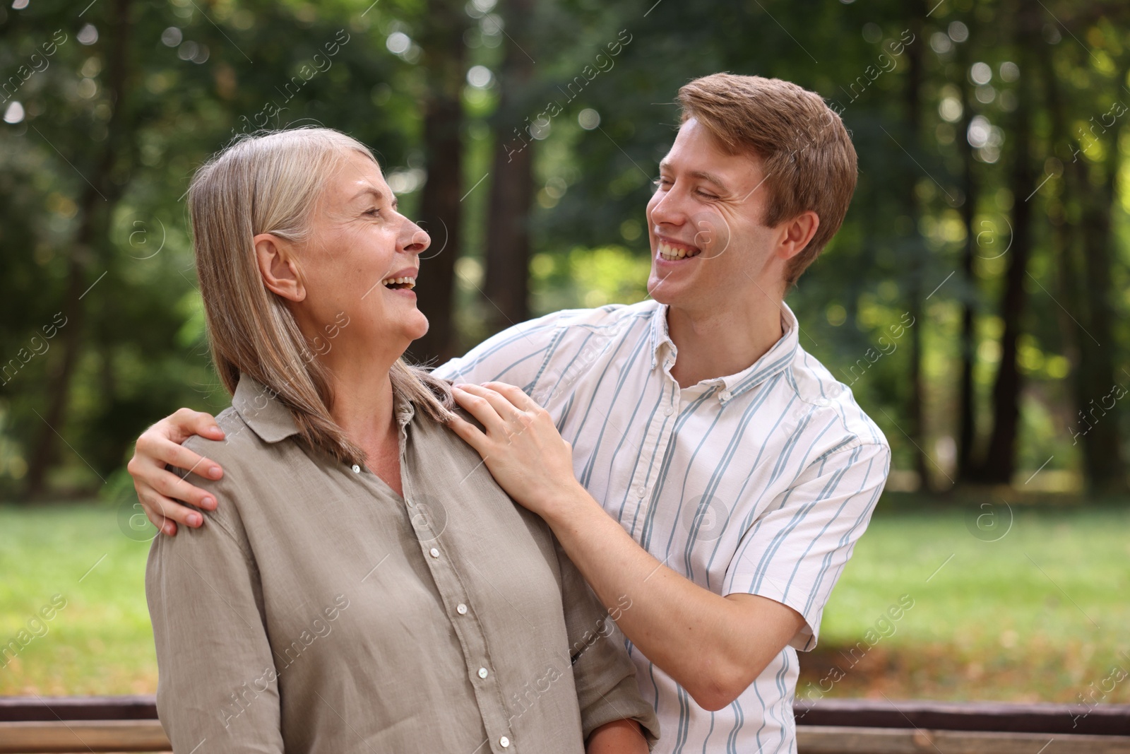 Photo of Mother and her son laughing in park. Family bonding