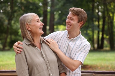 Photo of Mother and her son laughing in park. Family bonding