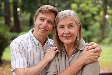 Photo of Smiling mother and her son in park. Family bonding