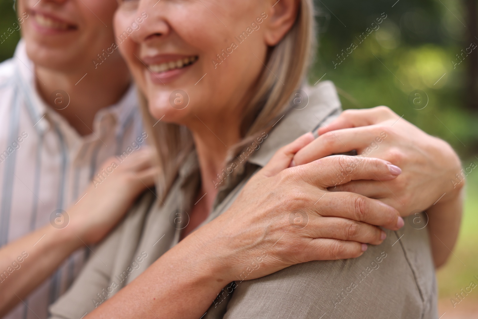 Photo of Smiling mother and her son outdoors, closeup. Family bonding