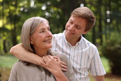 Photo of Smiling mother and her son in park. Family bonding