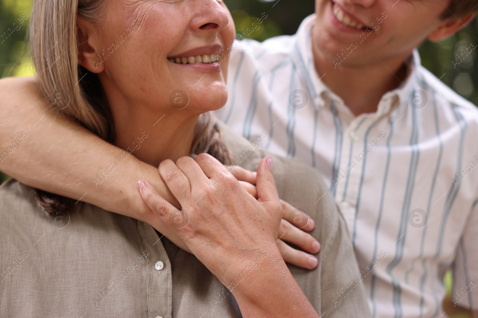 Photo of Smiling mother and her son outdoors, closeup. Family bonding
