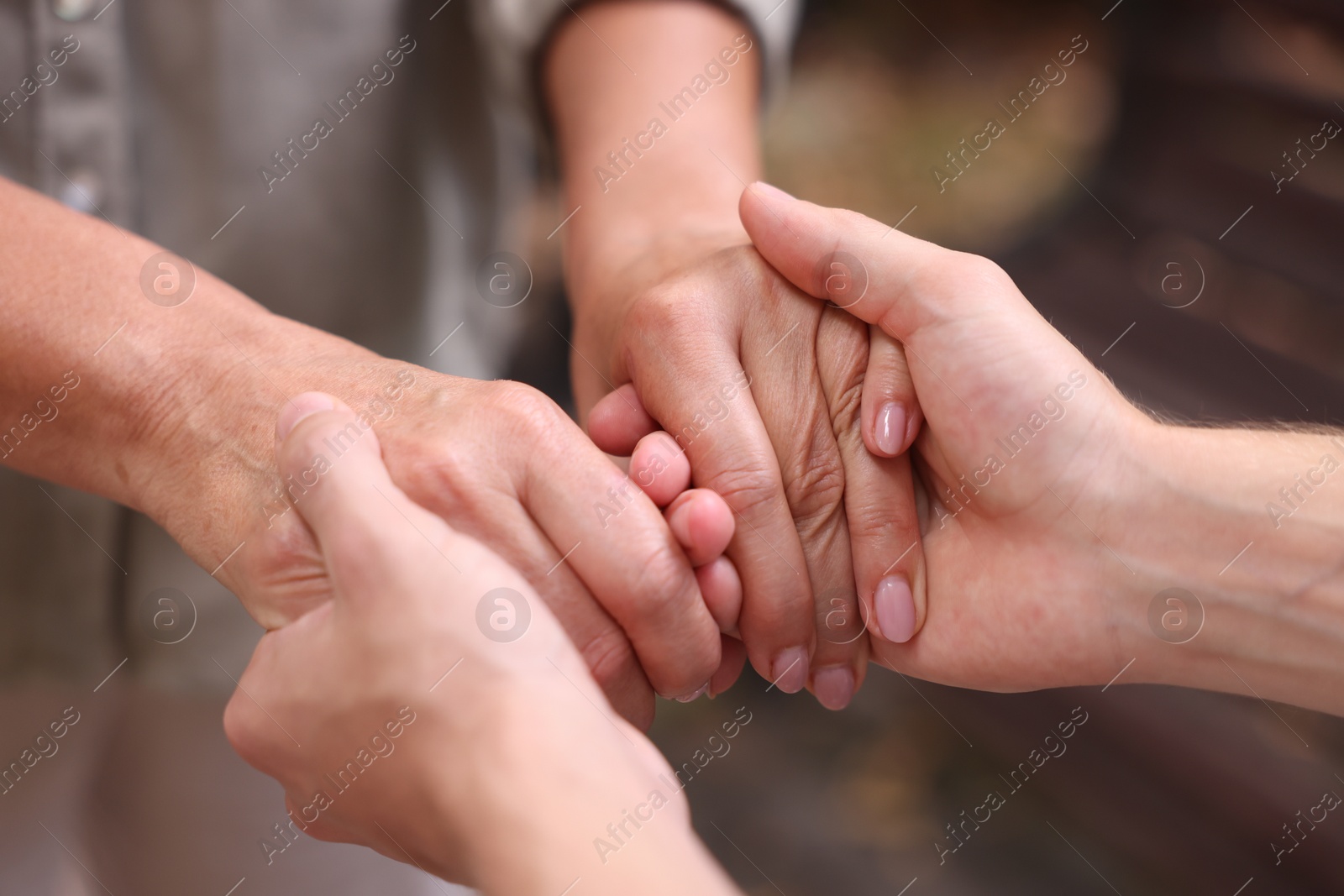 Photo of Son and his mother holding hands outdoors, closeup