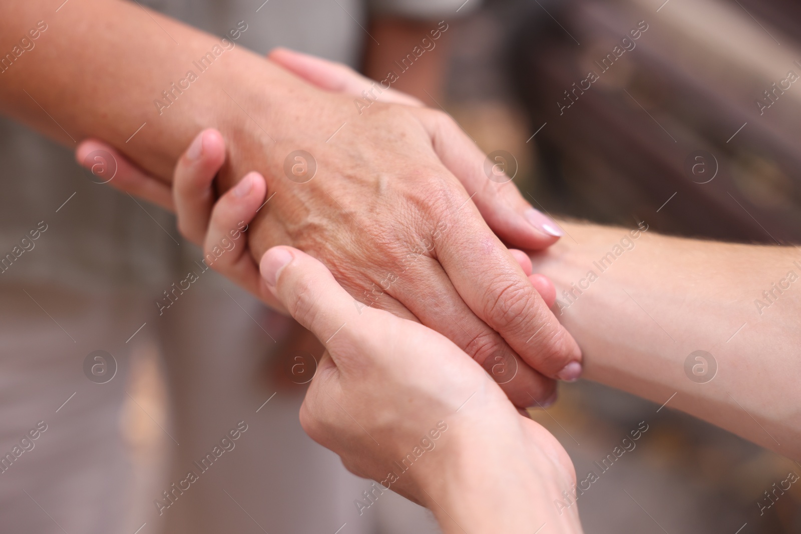 Photo of Son and his mother holding hands outdoors, closeup