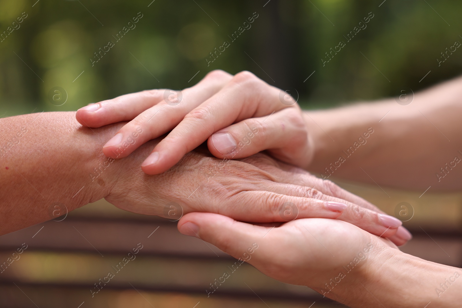 Photo of Son and his mother holding hands outdoors, closeup