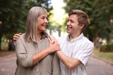 Photo of Smiling mother and her son in park. Family bonding