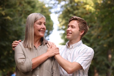 Photo of Smiling mother and her son outdoors. Family bonding