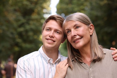 Photo of Smiling mother and her son outdoors. Family bonding