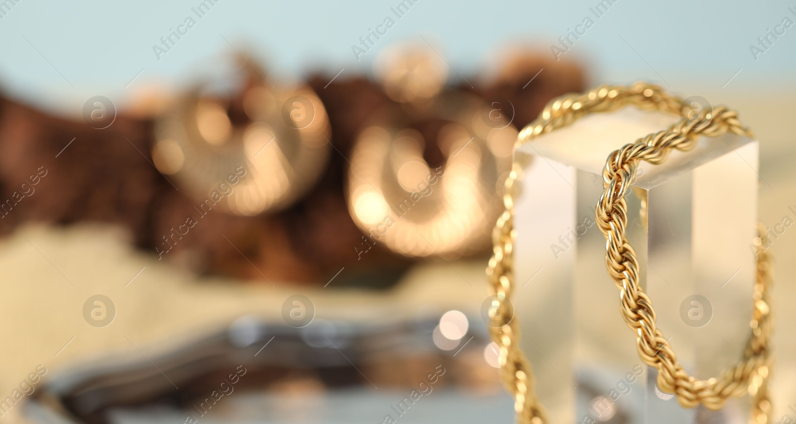 Photo of Beautiful gold chain on blurred background, closeup. Space for text