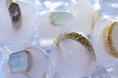 Photo of Beautiful jewelry frozen in ice cubes, closeup