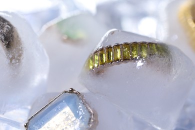 Photo of Beautiful jewelry frozen in ice cubes, closeup